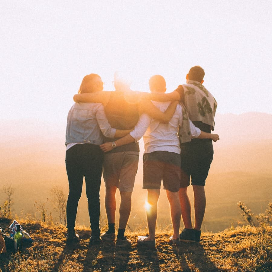 Grupo de amigos abrazados ante un atardecer